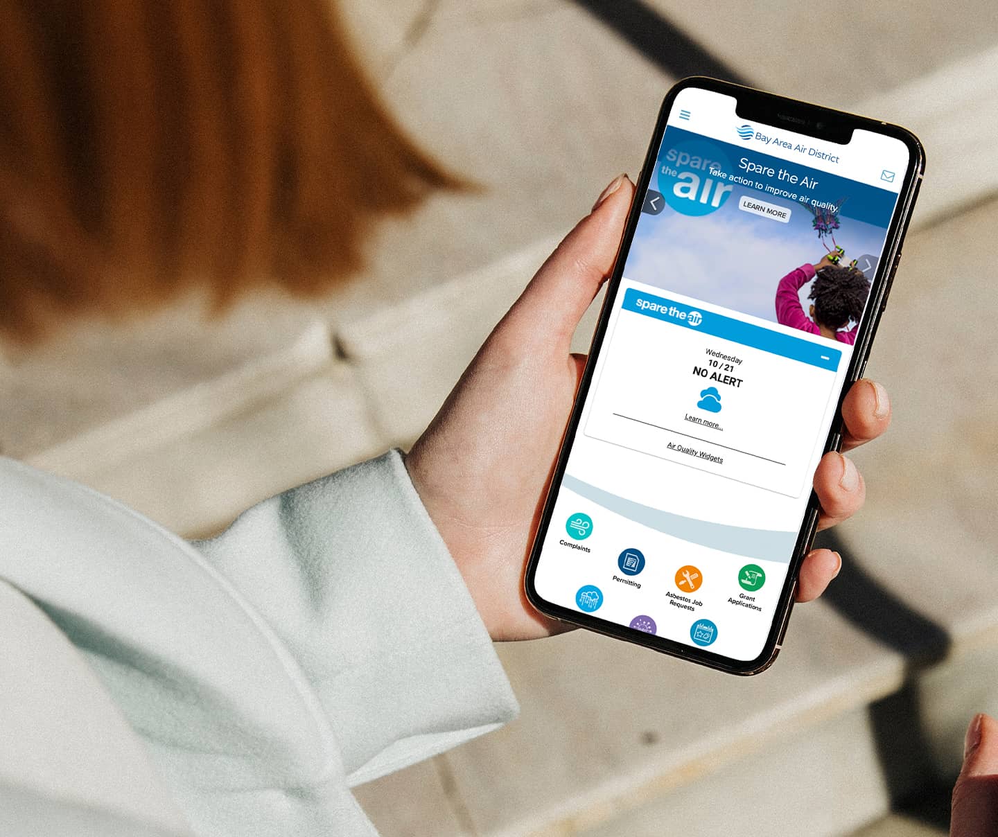 Woman walking in a city looking at the city's website