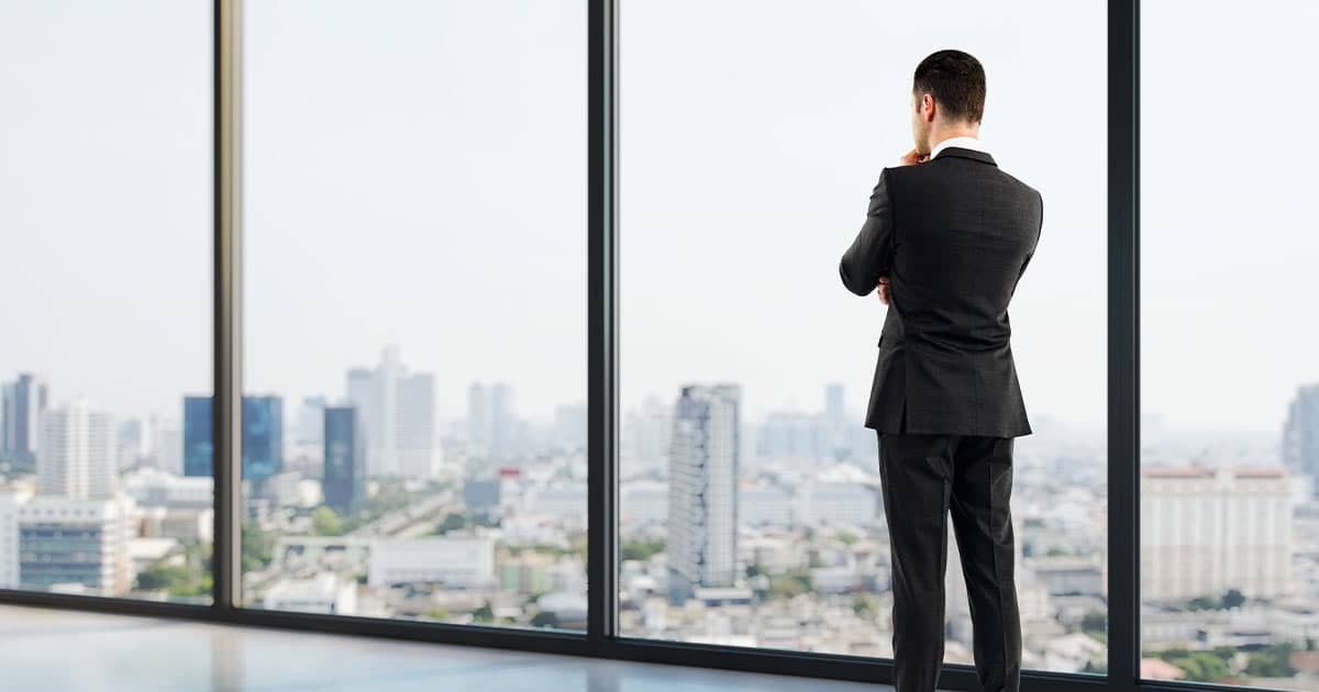 Businessman looking out window in a big city