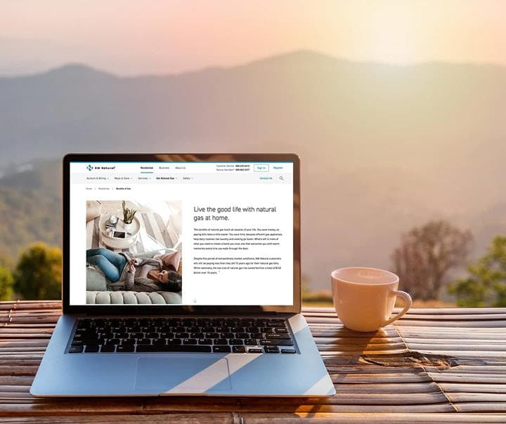 Laptop screen with NW Natural site with a view of the mountains in sunrise