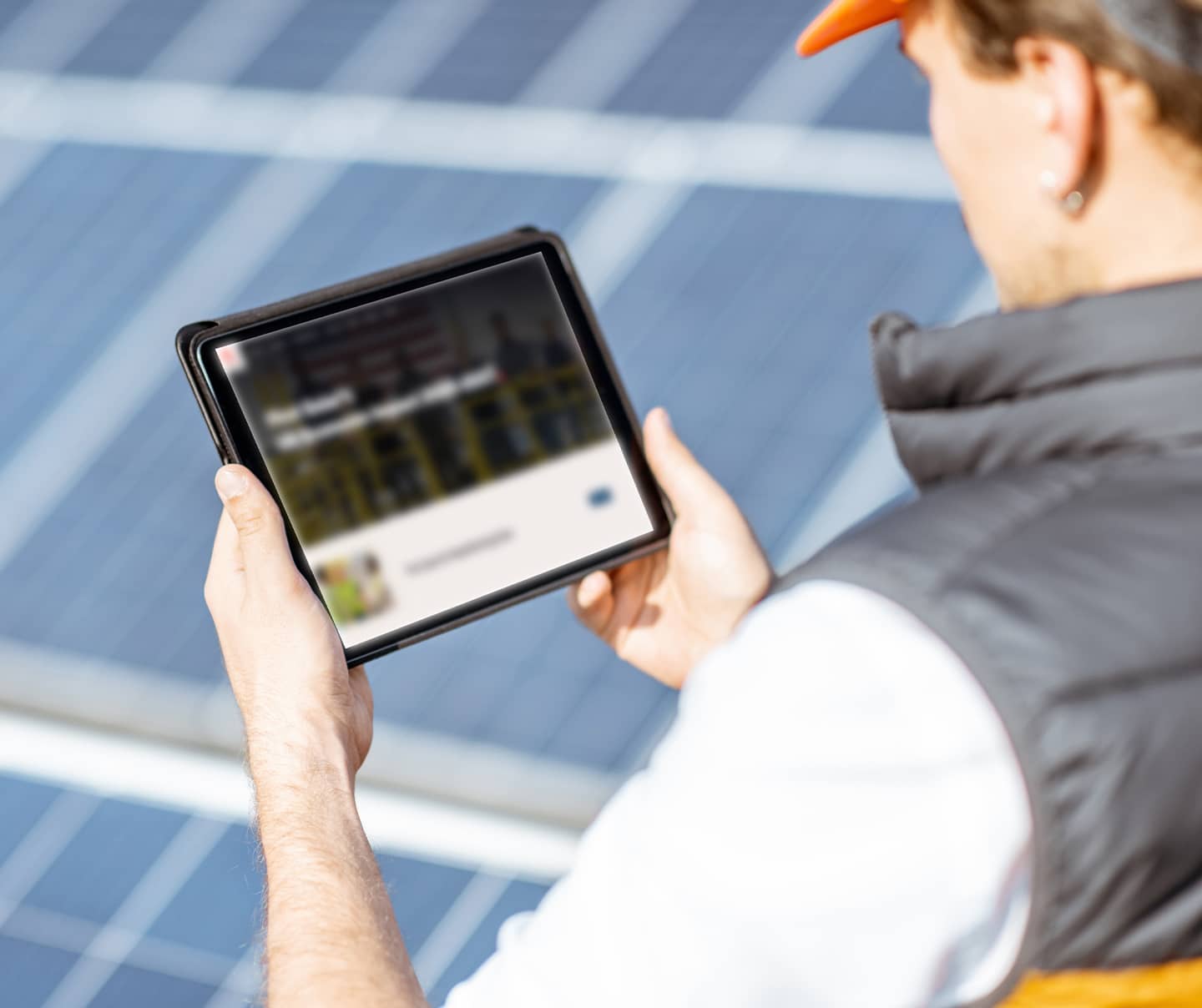 Engineer looking at website in front of solar panels
