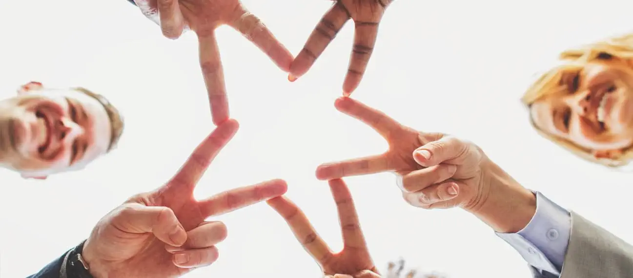team of co-workers making a star with their fingers