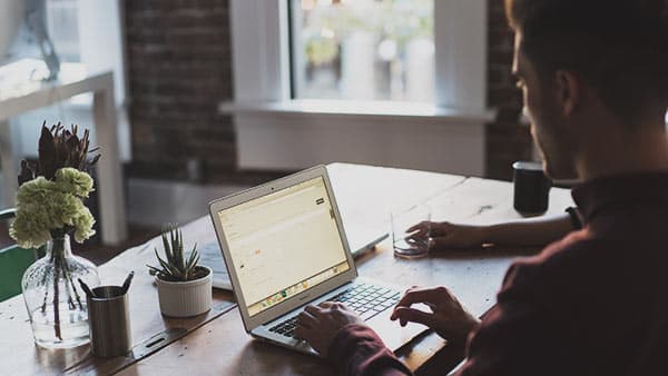man typing on laptop