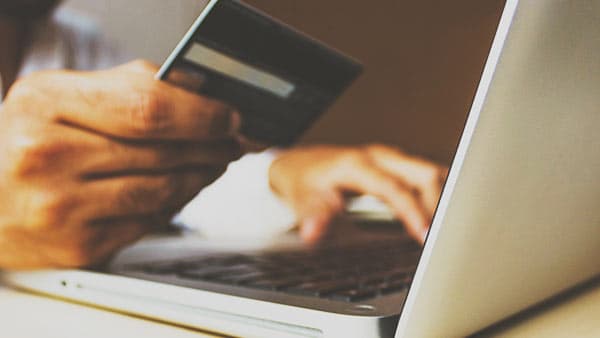 person entering credit card info on laptop
