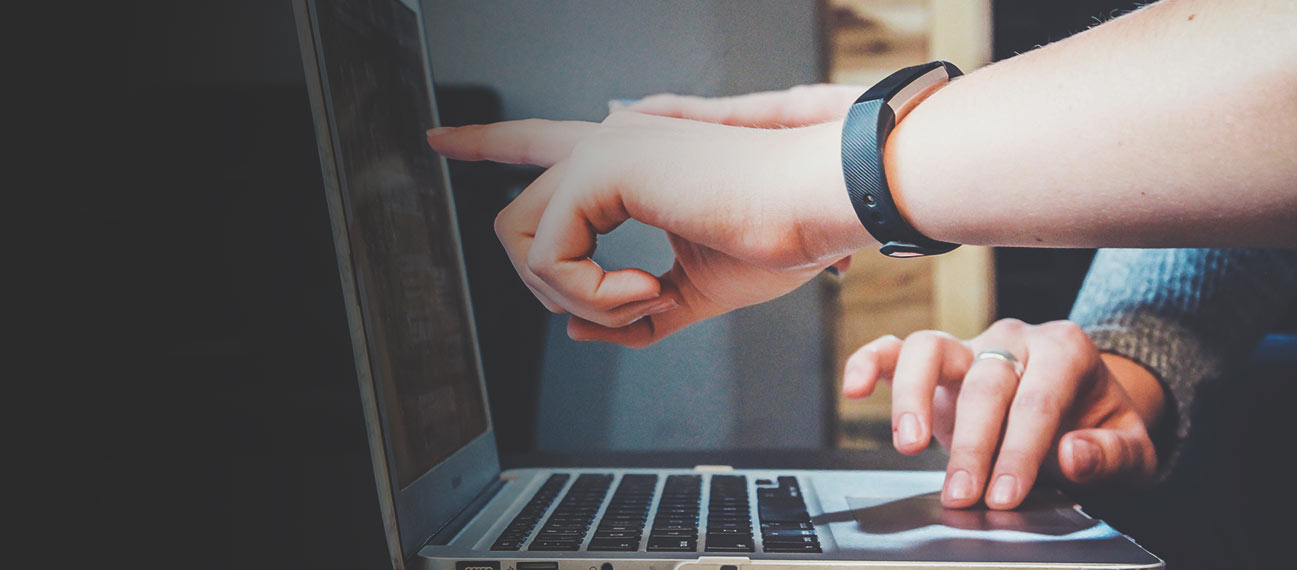 People using and pointing at laptop screen