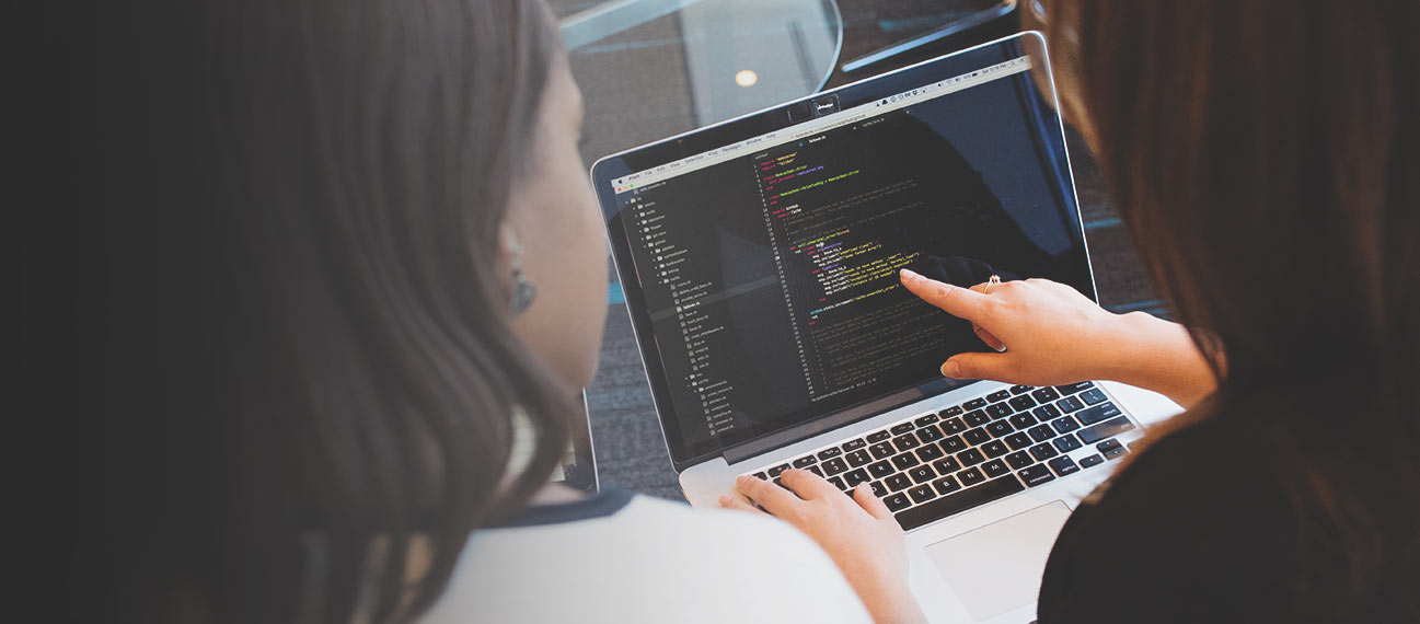 Women programmers viewing laptop screen