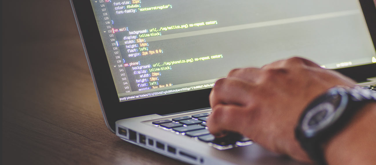 programmer's hand on laptop keyboard