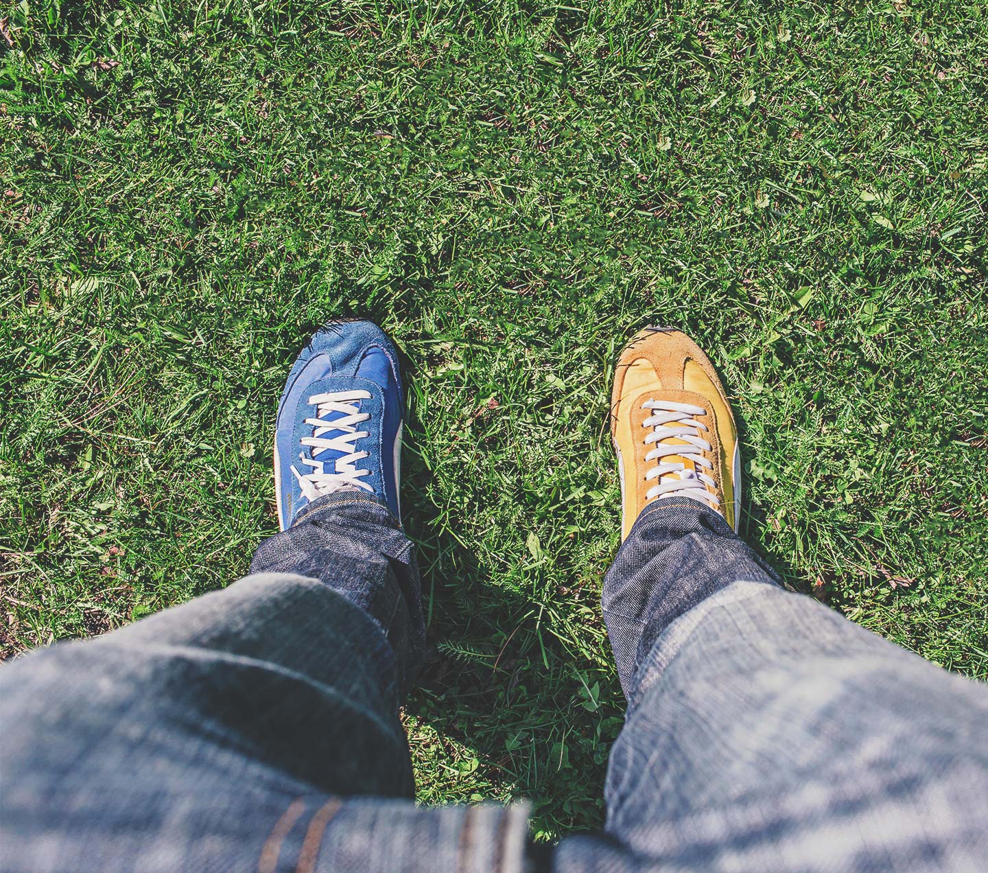 Man wearing one yellow shoe and one blue shoe