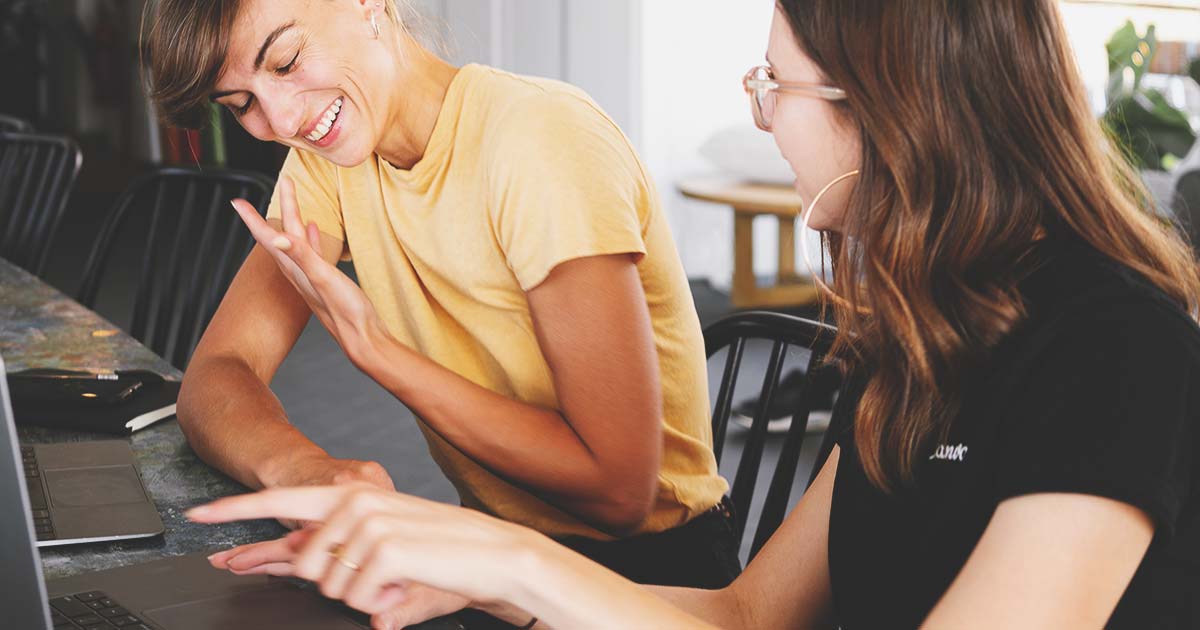 Two women reviewing their web assets in a DAM
