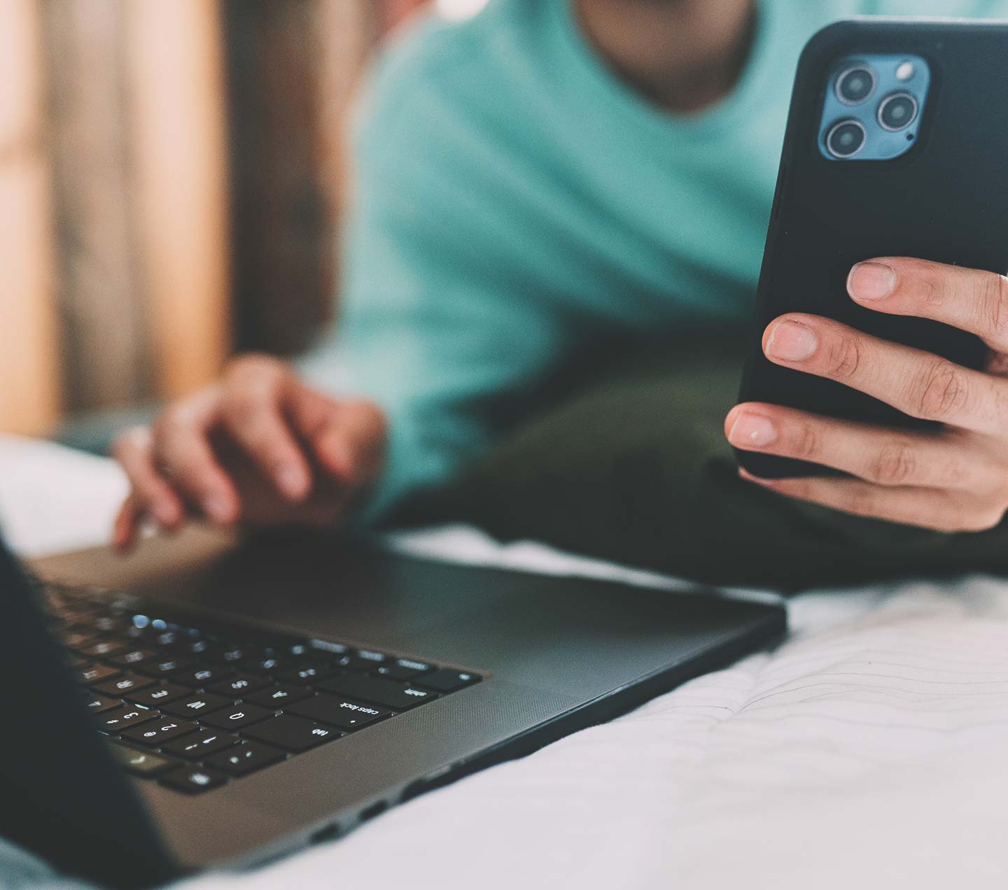 Person using both laptop and mobile phone