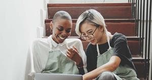 Two people collaborating on a laptop