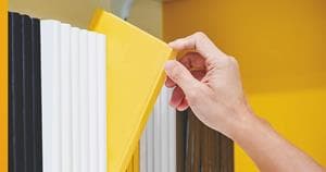 Person selecting a book in a shelf
