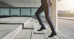 Business man going up the stairs representing upgrade