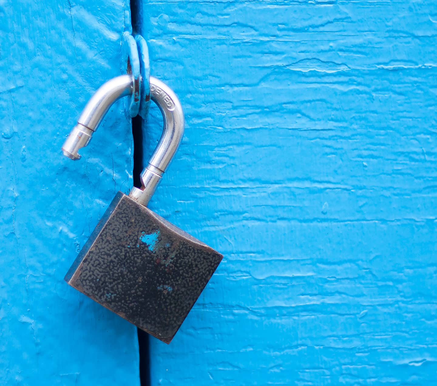Open lock on a blue door.