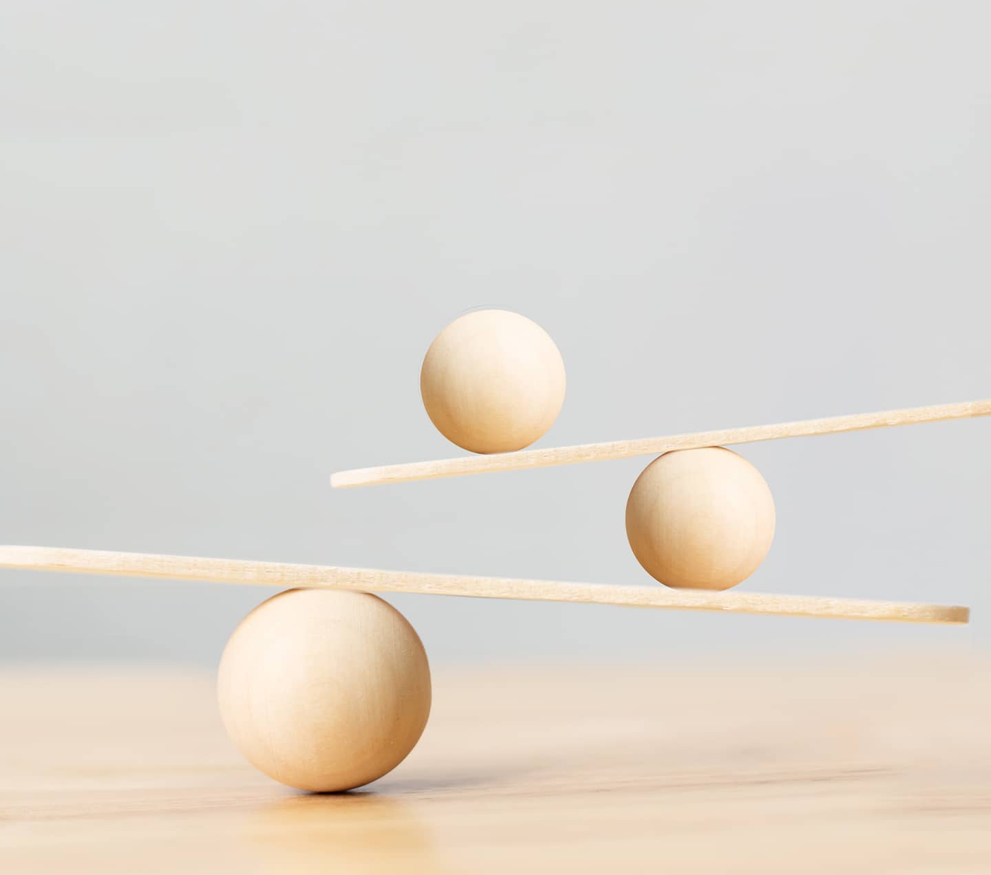 Wooden scale balancing on seesaw.