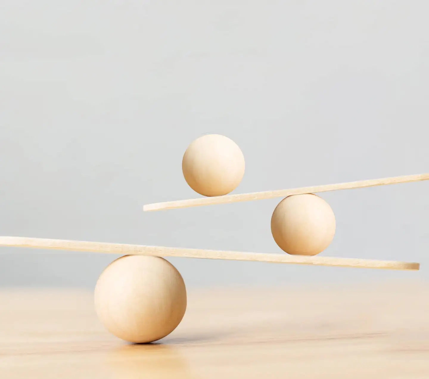 Wooden scale balancing on seesaw.