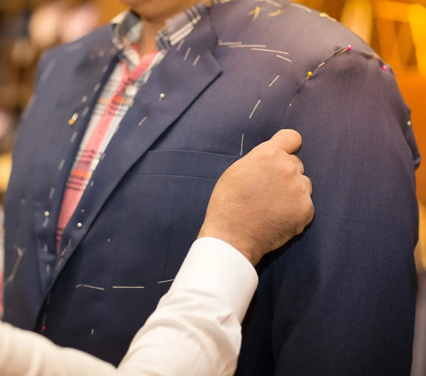 Tailor working with custom made suit