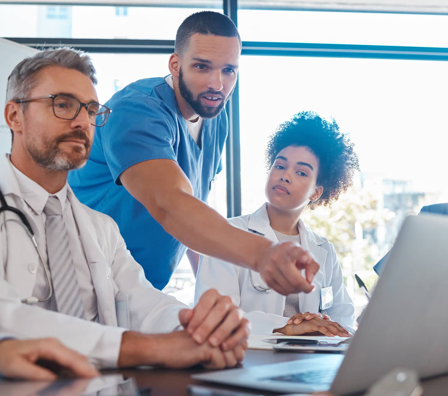 Doctors in a meeting looking at a laptop screen