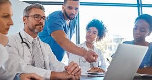 Doctors in a meeting looking at a laptop screen