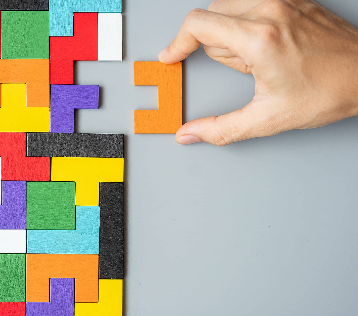 Hand connecting geometric shape block representing configurations