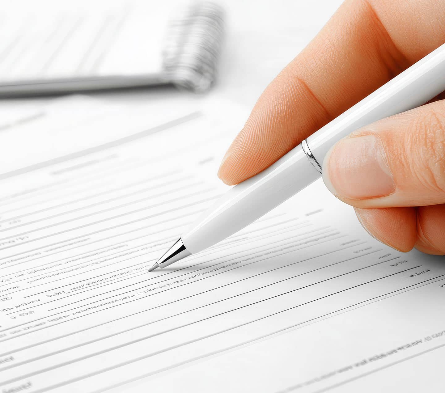 Hand holding a pen, filling out a form