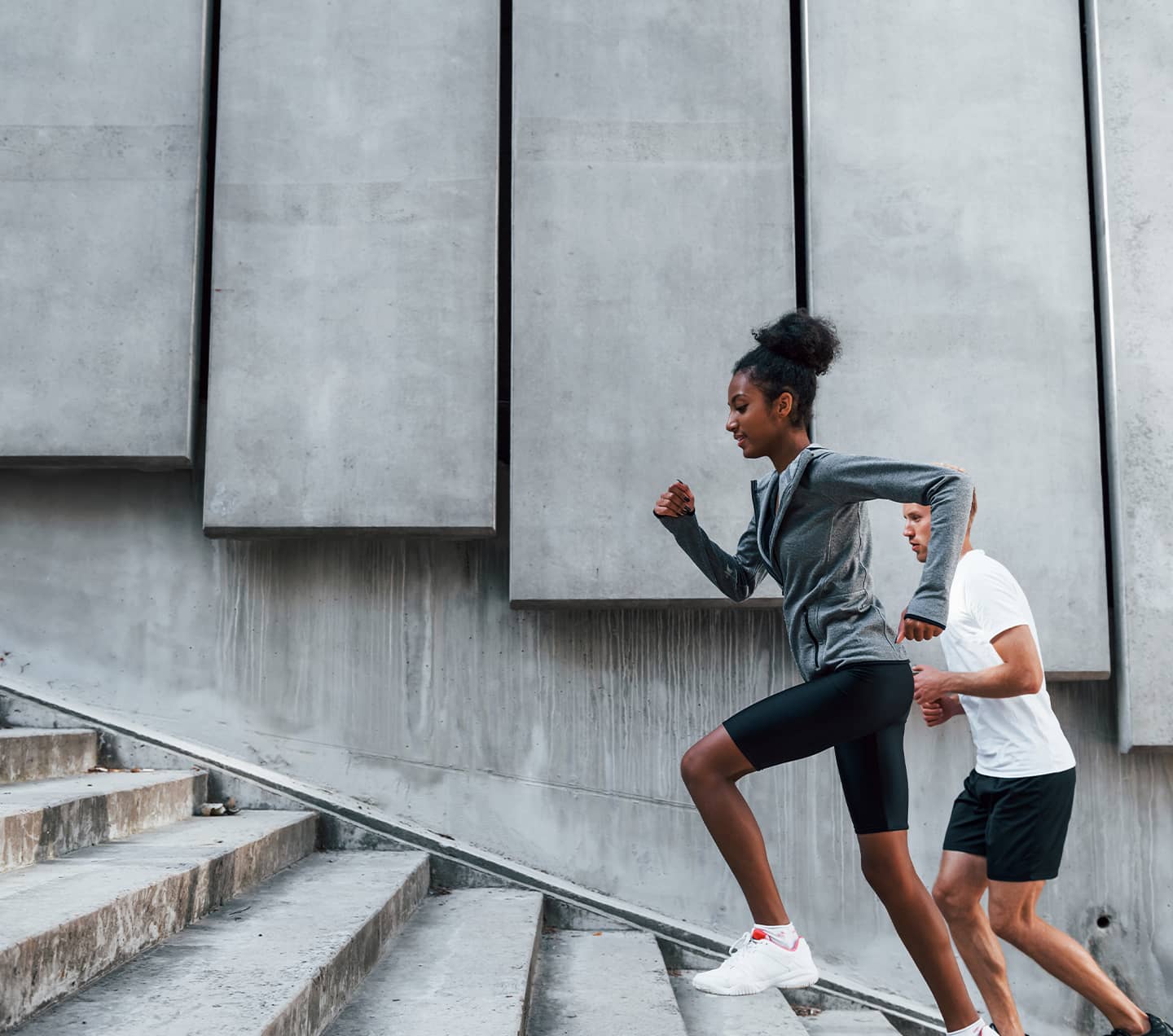 Athletic man and woman going up stairs