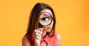 Woman looking though a magnifying glass