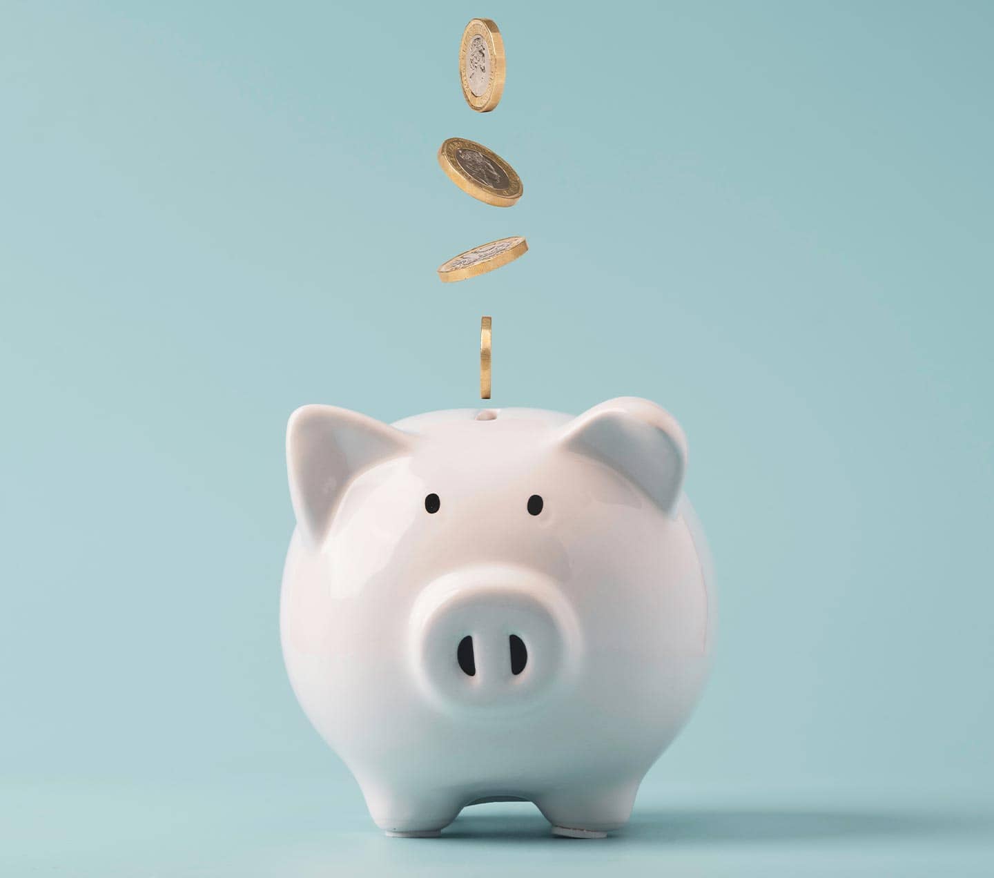 Coins falling to white piggy saving
