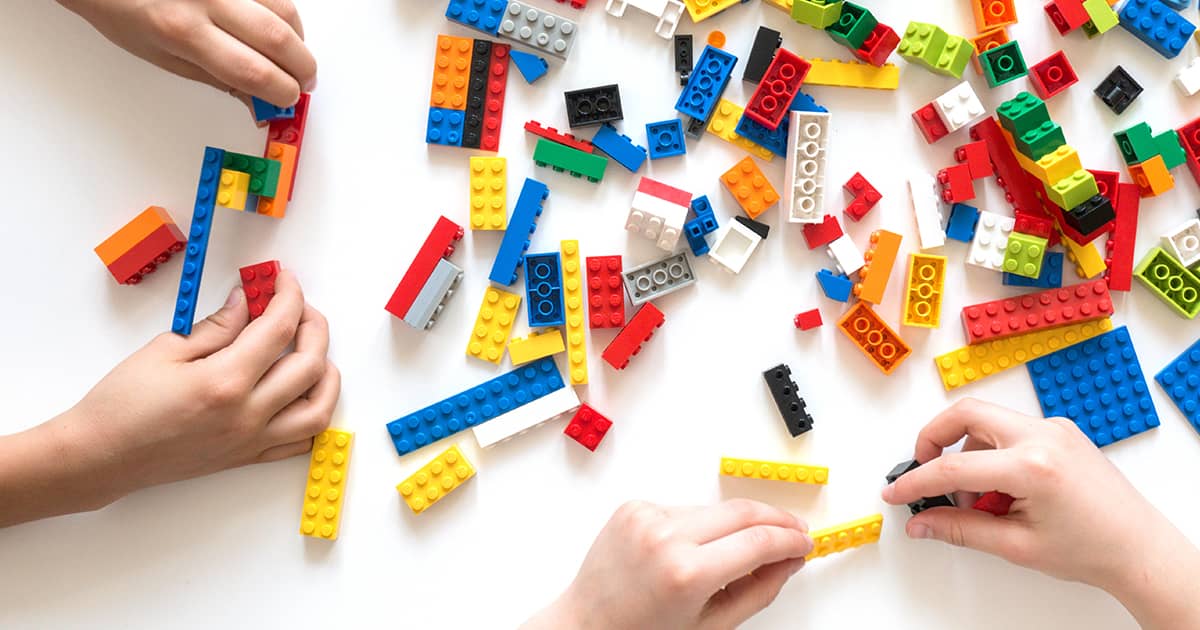 Hands building legos