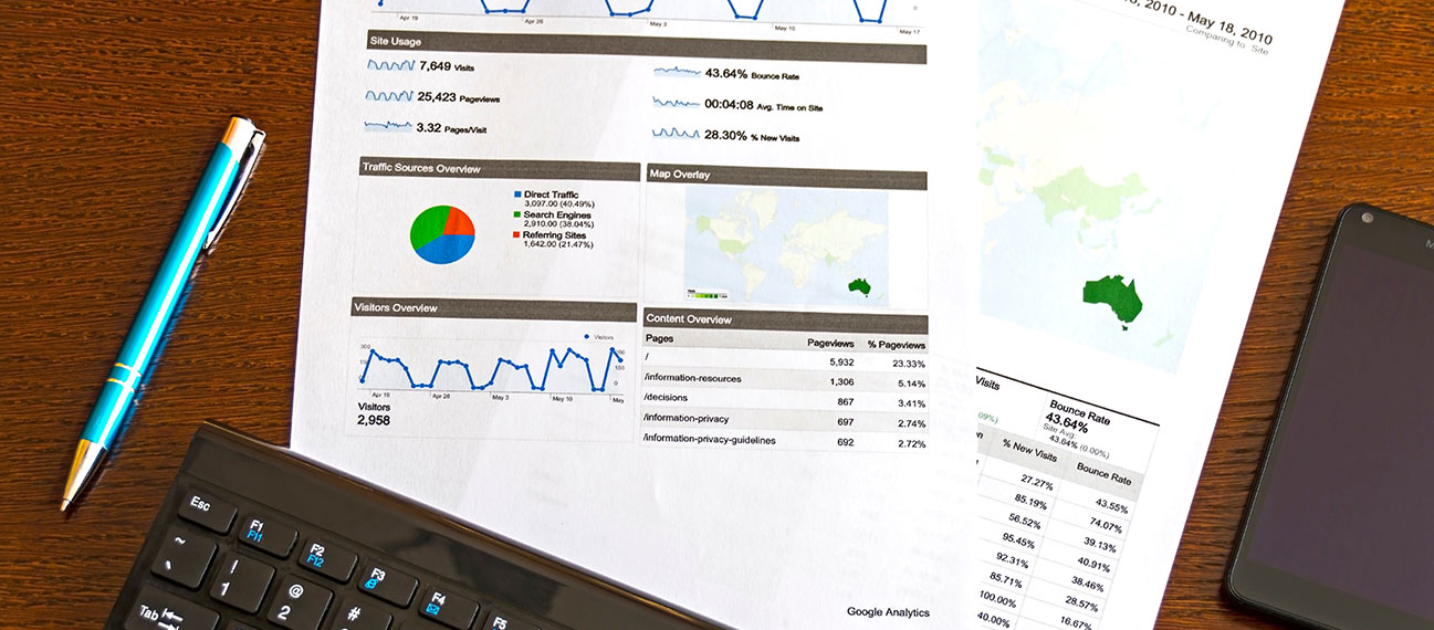 Google analytics reports prints pencil keyboard a mobile phone on top of table