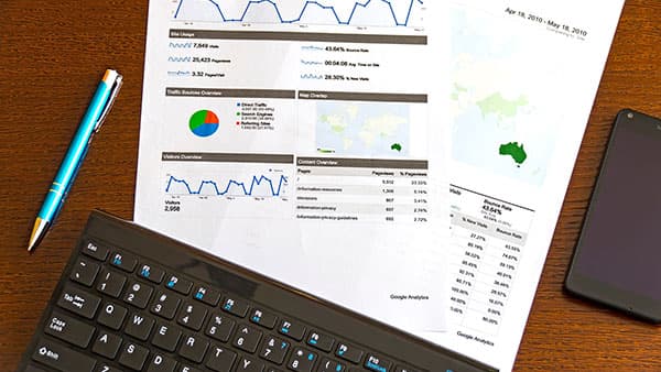 Google analytics reports prints pencil keyboard a mobile phone on top of table