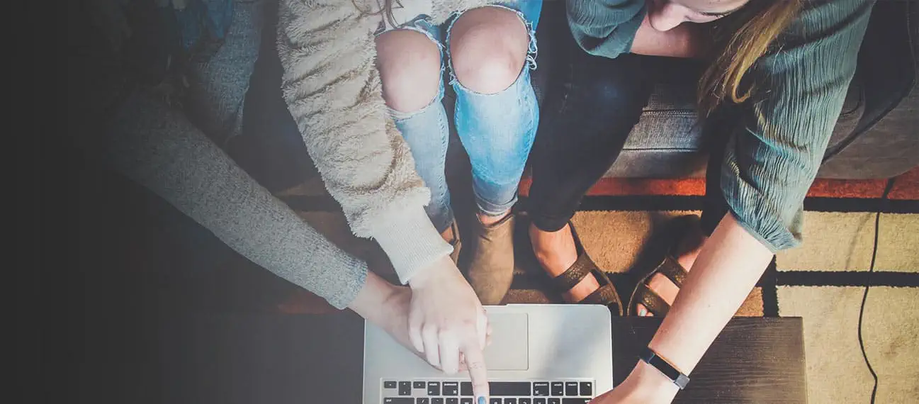 Young women looking and pointing at computer screen