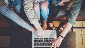 Young women looking and pointing at computer screen